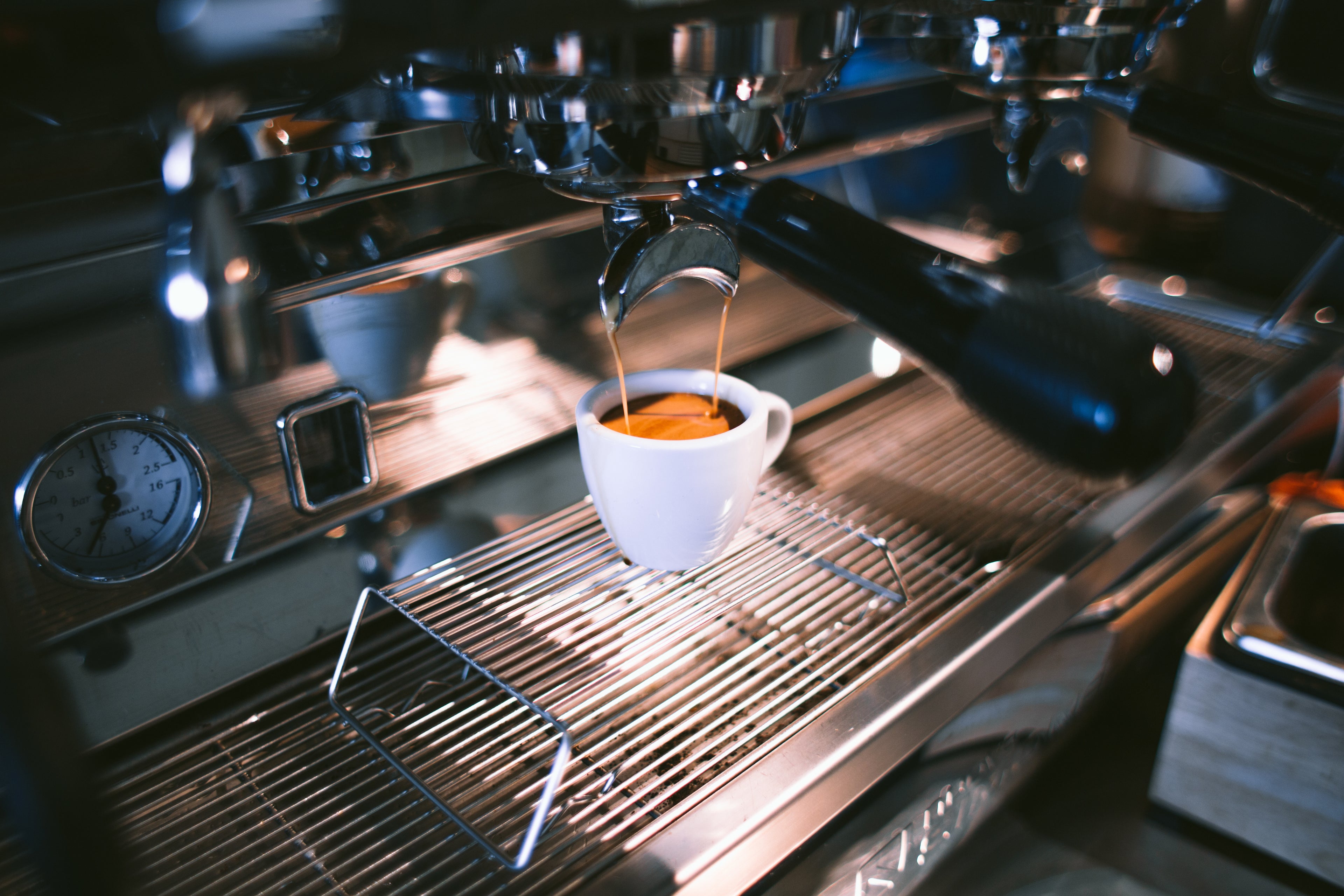 Delicious golden coffee filling a snow white coffee cup on a silver wire rack